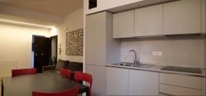 - une cuisine avec une table, des chaises rouges et un évier dans l'établissement Residenza Pellacani, à Bologne 24 autres photos