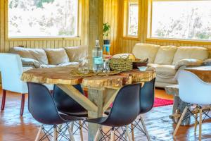 uma sala de estar com uma mesa de madeira e cadeiras em Vertientes De Pumillahue, Chiloe em Pumillahue