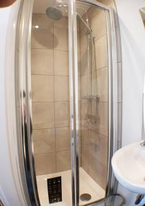 a shower with a glass door next to a sink at Toll Bridge Studio in Selby
