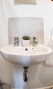 a white sink in a bathroom with a mirror at Toll Bridge Studio in Selby