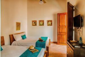 a bedroom with a bed and a tv and a table at Casa D´Remedios La Bella Hotel Boutique in Ciénaga