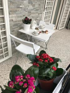 un tavolo con sedie e fiori sul balcone di Sweet Home Roma a Roma