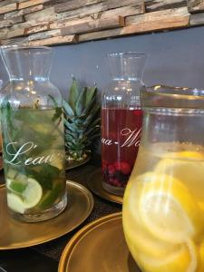 three glass vases with drinks on plates on a table at Charmehotel Kruishof in Ostend