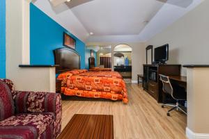Scottish Inn and Suites Highway Six South في Mission Bend: غرفه فندقيه بسرير واريكه