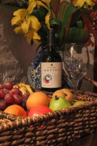 a basket of fruit with a bottle of wine and a glass at Hotel La Casa de Maty in Tapalpa