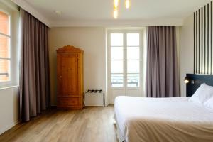 Hôtel & Spa Le Moulin de Moissac في مواساك: غرفة نوم بسرير كبير ونافذة