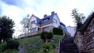 a large white house on a hill with stairs at La villa des Savoyards in Vielsalm