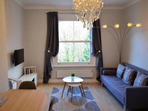 a living room with a blue couch and a window at London, Kensington and Chelsea Flat in London