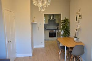 a kitchen with a table and chairs and a chandelier at London, Kensington and Chelsea Flat in London