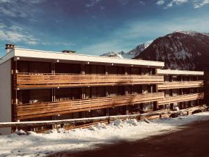 a building with snow in front of a mountain at Le Solaret in Courchevel