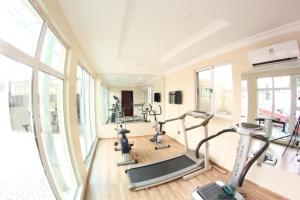 a gym with cardio machines in a room with windows at Celia's Suites in Abeokuta