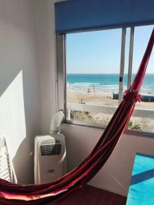 a hammock in a room with a view of the beach at Beach & Relax - Studio in Costa da Caparica