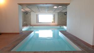 ein Schwimmbecken mit blauem Boden und einem Fenster in der Unterkunft La Fortezza Alta in Avigliano