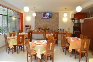 een eetkamer met tafels en stoelen en een tv bij Hotel Puno Terra in Puno