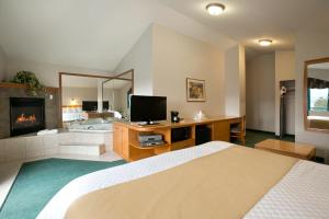 a bedroom with a bed and a tv and a fireplace at Ramada Merritt in Merritt