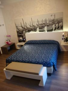 a bedroom with a bed and a painting of a boat at Hotel Venezia in Caorle