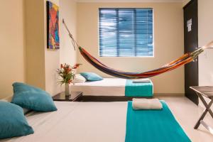 a room with a bed and a hammock in it at Palma Real Hotel Boutique in Acacías
