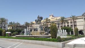 uma fonte em frente a um edifício com uma estátua em Sherryflat Alcázar - Parking em Jerez de la Frontera