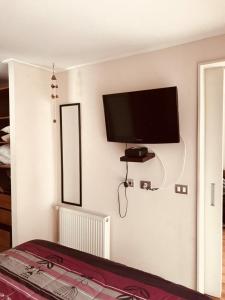 Depto Marina Poniente في فينيا ديل مار: غرفة نوم مع تلفزيون بشاشة مسطحة على الحائط
