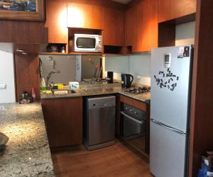 a kitchen with a refrigerator and a microwave at Depto Marina Poniente in Viña del Mar