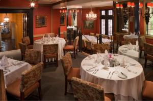 uma sala de jantar com mesas e cadeiras brancas em Henley Park Hotel em Washington