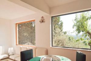 een eetkamer met een tafel en een groot raam bij Stunning Country House overlooking Tuscany hills in Lorenzana