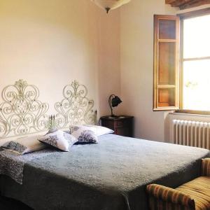 LorenzanaにあるStunning Country House overlooking Tuscany hillsのベッドルーム1室(大型ベッド1台、枕2つ付)