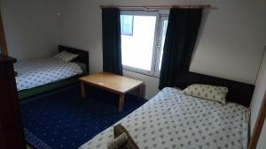 a small room with two beds and a window at Yukiyama Chalet Apartments in Furano