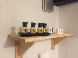 a shelf with four bottles on it on a wall at Findon Rest Ltd in Worthing