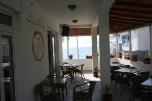 a restaurant with tables and chairs and a view of the ocean at Casa Mila apartments & bungalows in Ulcinj