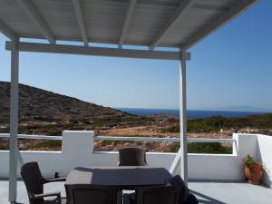 a patio with a table and chairs and the ocean at Sunset in Irakleia