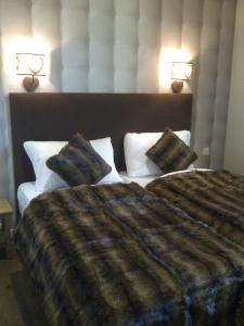 a bedroom with a large bed with two pillows at Hotel de la Lande in Le Brassus