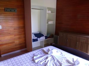 a bedroom with a bed and a closet and shelves at Chale dos Beija Flores in Gramado