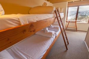 two bunk beds in a room with a ladder at Nolyski in Mount Hotham
