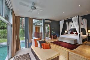 een slaapkamer met een bed en een groot raam bij Ambong Pool Villas - Private Pool in Pantai Cenang