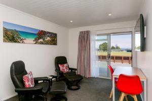 Habitación con sillas, mesa y ventana en eMotel, en Taupo