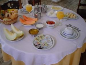 a table with a white table cloth with fruit on it at Hotel Areia Branca in Caraguatatuba