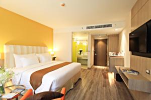 a hotel room with a large bed and a bathroom at Bangkok Midtown Hotel in Bangkok
