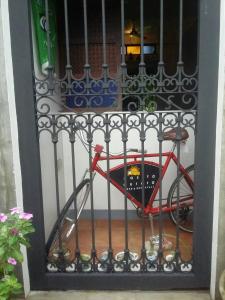Una puerta de hierro con una bicicleta roja detrás. en Casita Aurora Bed and Breakfast, en Legazpi
