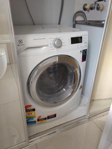 a washing machine in a shelf in a bathroom at Oasis Private 2 Bed Apartment in Caloundra