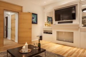 een woonkamer met een televisie en een tafel bij Świętojańska Old Town Deluxe Apartament by BookingHost in Warschau