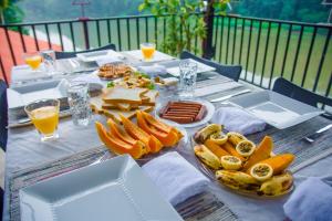 a table with food and drinks on top at Chaminrich Homestay in Kandy