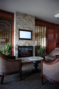 a living room with a fireplace and a tv at Motel Du Chevalier in Gatineau