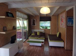 哈皮蒂的住宿－JUSTMOOREA Location Haapiti，一间带两张床和一张沙发的客厅