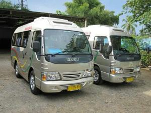 zwei Busse, die nebeneinander auf einem Parkplatz geparkt sind in der Unterkunft Taratak Homestay in Bukittinggi