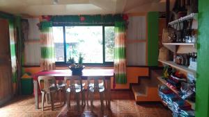 a dining room with a table and chairs and a window at Batad Lhorens Inn and Restaurant in Banaue