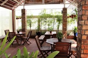 un patio al aire libre con mesas, sillas y plantas en Ananas Family Hotel en Ho Chi Minh