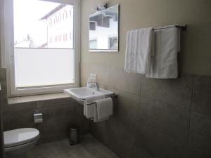 a bathroom with a sink and a toilet and a window at Kössen DORF41 TOP2 in Kössen