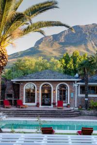 a house with a swimming pool and palm trees at Boutique Villa Guesthouse in Somerset West