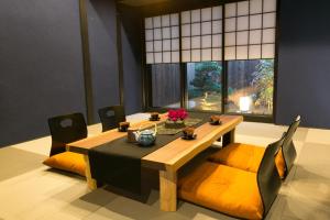 ein Esszimmer mit einem Tisch, Stühlen und einem Fenster in der Unterkunft Hosta Umekoji Akari in Kyoto